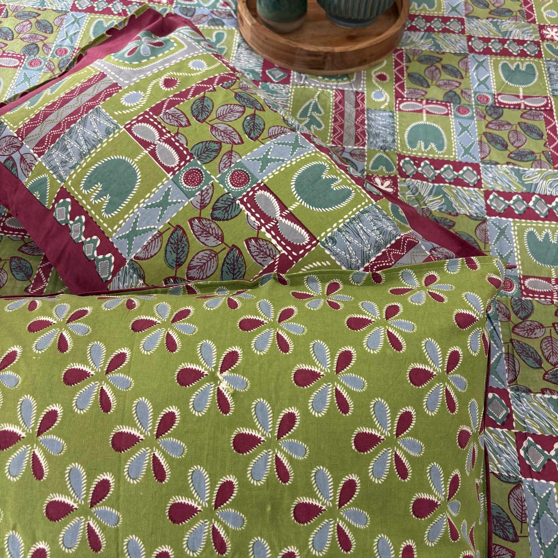 Designer patchwork bed cover with handcrafted floral cushions